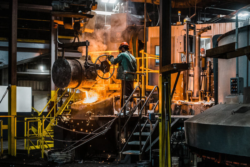 worker pouring material into casting